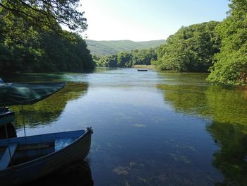 Boat moored in lake against sky