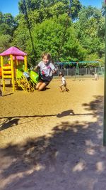 Boy playing on swing in playground