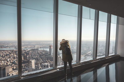 Man looking through window in city