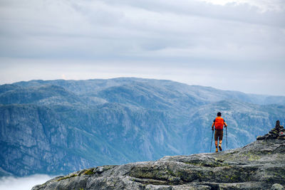 Rear view of man looking at mountain against sky