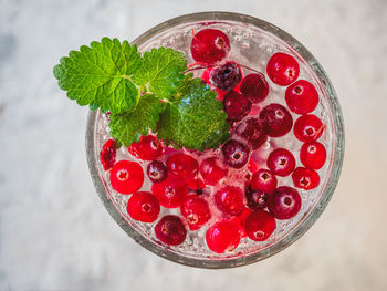 A light soft drink with mint and lingonberry in a glass glass from a high point of view