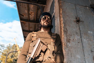 Low angle view of young man against built structure