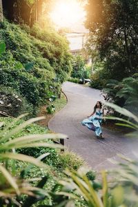 Children riding bicycle on footpath amidst trees
