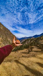 Midsection of person on mountain against sky