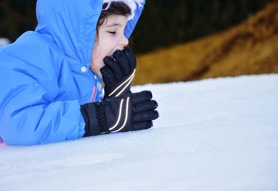 Boy in snow on field during winter