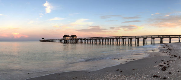 Pier over sea against sky during sunset