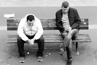 Full length of men sitting outdoors