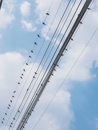 Low angle view of power cables against sky