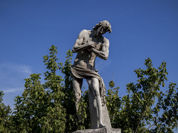 Low angle view of statue against blue sky