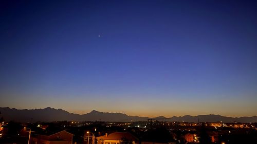 Illuminated city against sky at night