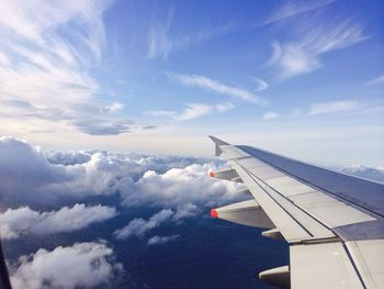 Cropped image of airplane flying over clouds