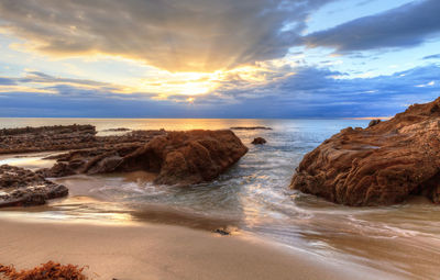 Scenic view of beach against sky during sunset