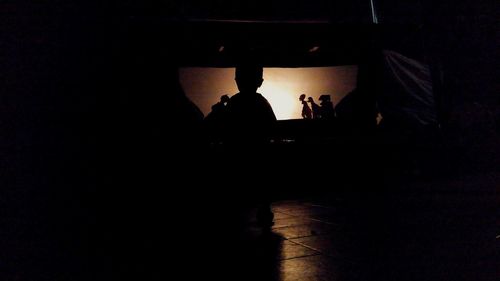 Silhouette of people in dark room