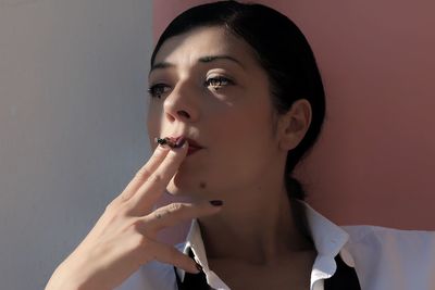 Close-up portrait of a beautiful young woman with cigarette