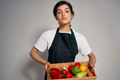 Portrait of young woman with fruits