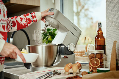 Woman cooking at home kitchen, use electric mixer to preparing dough