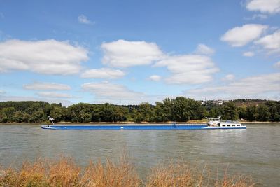 Boats sailing in river against sky