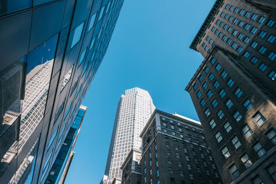 Low angle view of modern buildings against clear blue sky