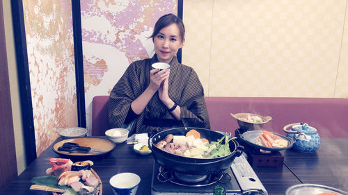 Portrait of young woman sitting on table and enjoy japanese food in hot spring hotel 