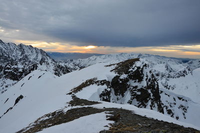 Scenic view of snowcapped mountains against sky during sunset