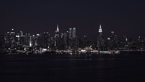 Illuminated cityscape against clear sky at night