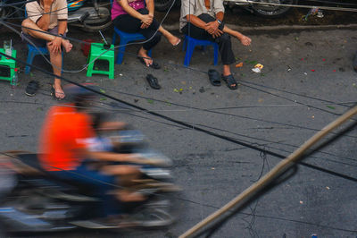 Low section of people walking on road in city