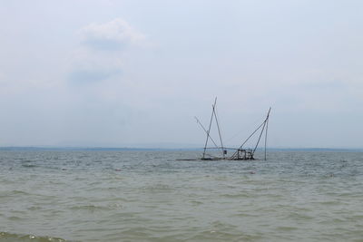 Sailboat sailing in sea against sky