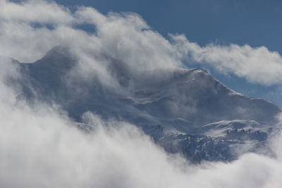 Scenic view of mountains against cloudy sky