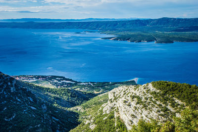 High angle view of sea and mountains against sky