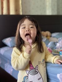 Portrait of cute girl lying on bed at home