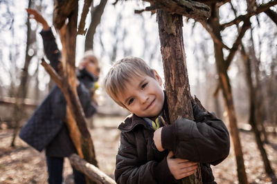 Portrait of boy on tree trunk