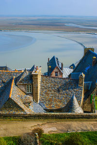 High angle view of townscape by sea against sky