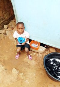 High angle view of boy sitting on wall