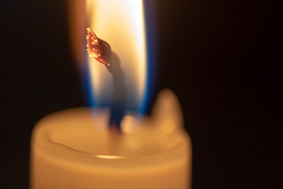 Close-up of lit candle against black background