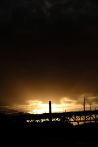 Silhouette field against sky during sunset