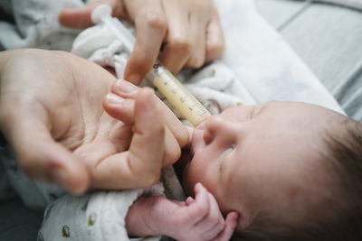 Woman feeding newborn baby boy with injection in hospital