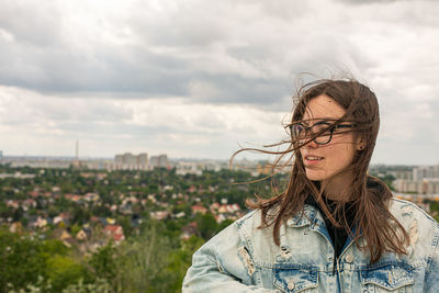 Portrait of woman standing against sky