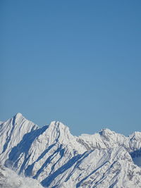 Scenic view of snowcapped mountains against clear blue sky