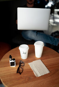 Midsection of man using laptop in cafe