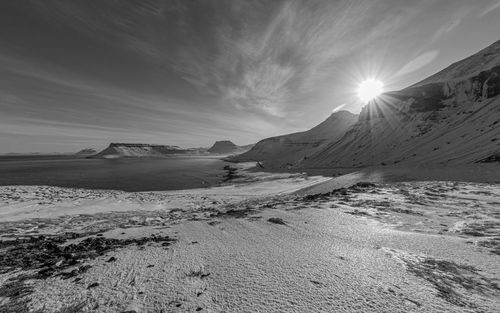 Full frame view of panoramic scenery with sun rising over snow covered mountains