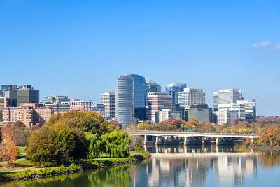 Buildings by river against sky