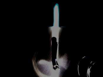 Close-up of lit candle in darkroom