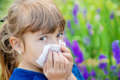 Close-up of girl blowing flowers