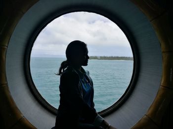 Side view of woman by window in ship