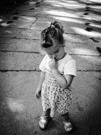 High angle view of little girl standing on footpath