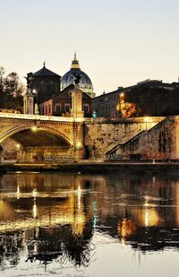 River in city against clear sky at dusk