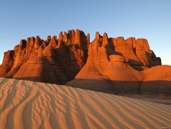 Rock formations against clear blue sky at sahara desert