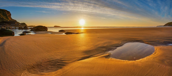 Scenic view of beach against sky during sunset