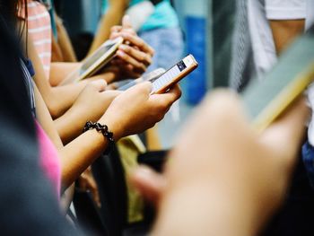 Midsection of women using phones 