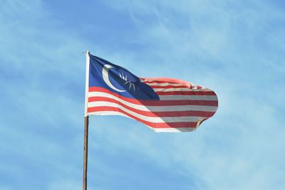 Low angle view of malaysian flag waving against sky